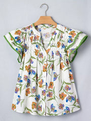 Cotton V-neck shirt with vibrant floral print, pintuck details, and green ruffled cuffs.