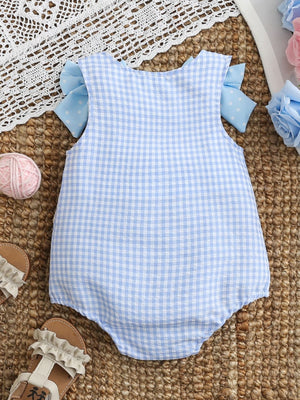 Baby one-piece in pastel blue gingham with polka dot bows on sleeves