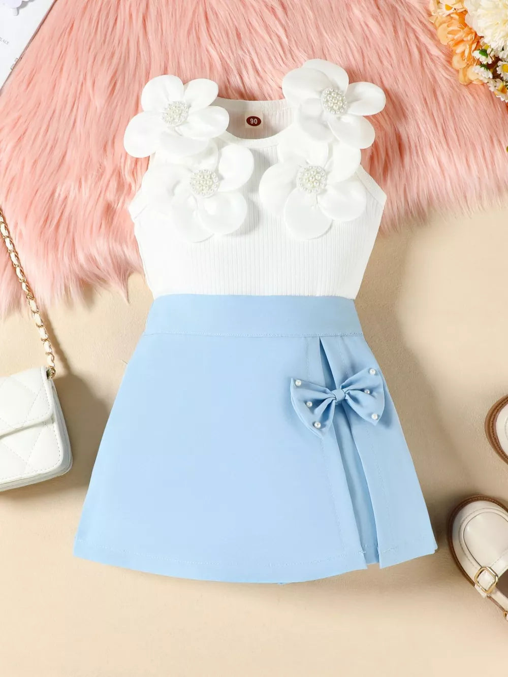 Baby girl sky blue skort set with white floral applique tank top and pearl bow detail.