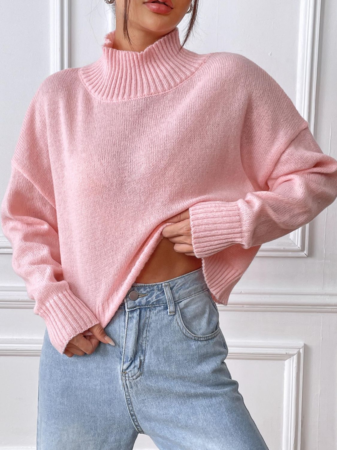 Blush pink ribbed turtleneck knit sweater with a cropped length and cuffed sleeves.