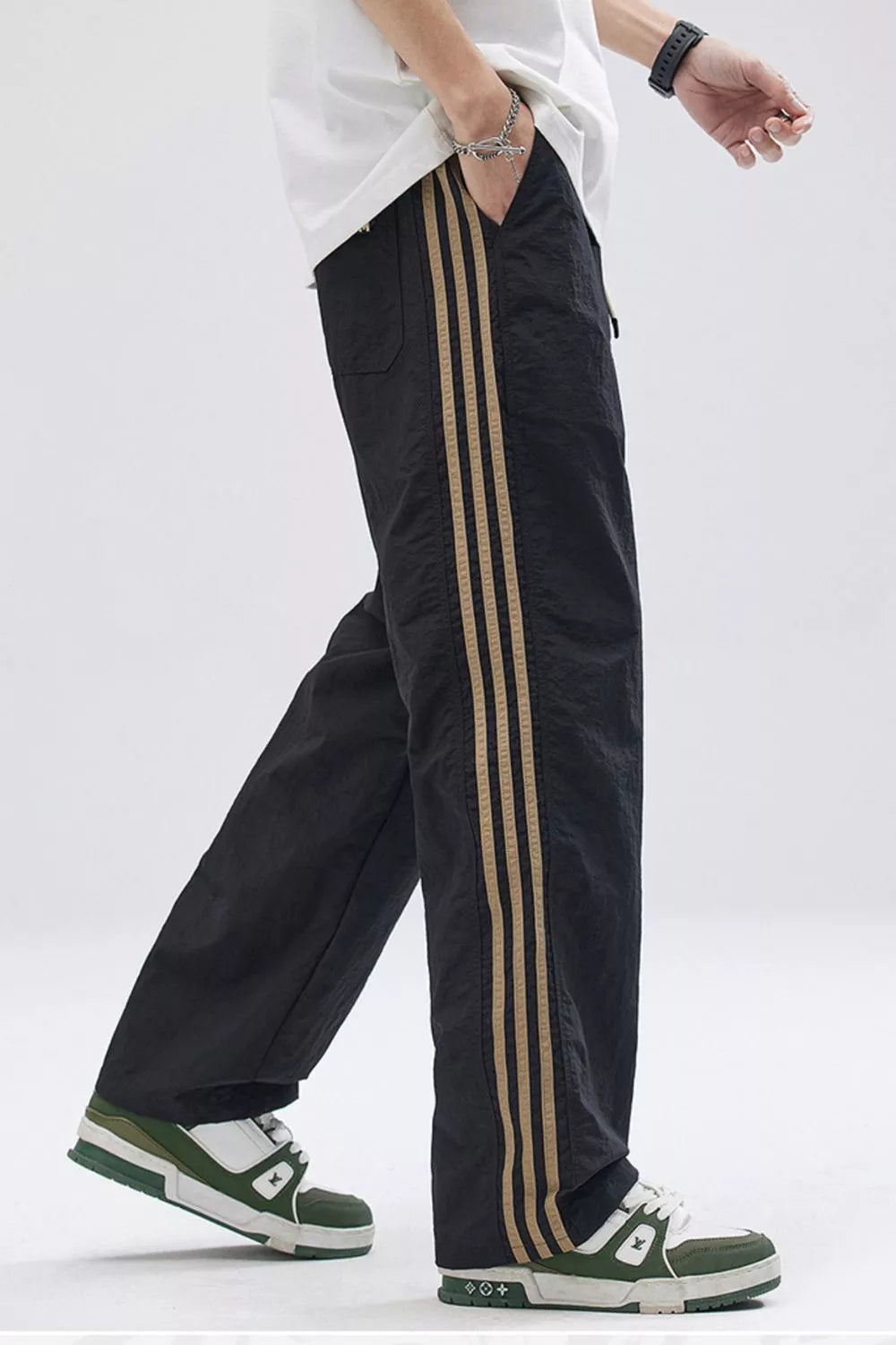 Black relaxed fit sweatpants with tan side stripes and a wide leg.