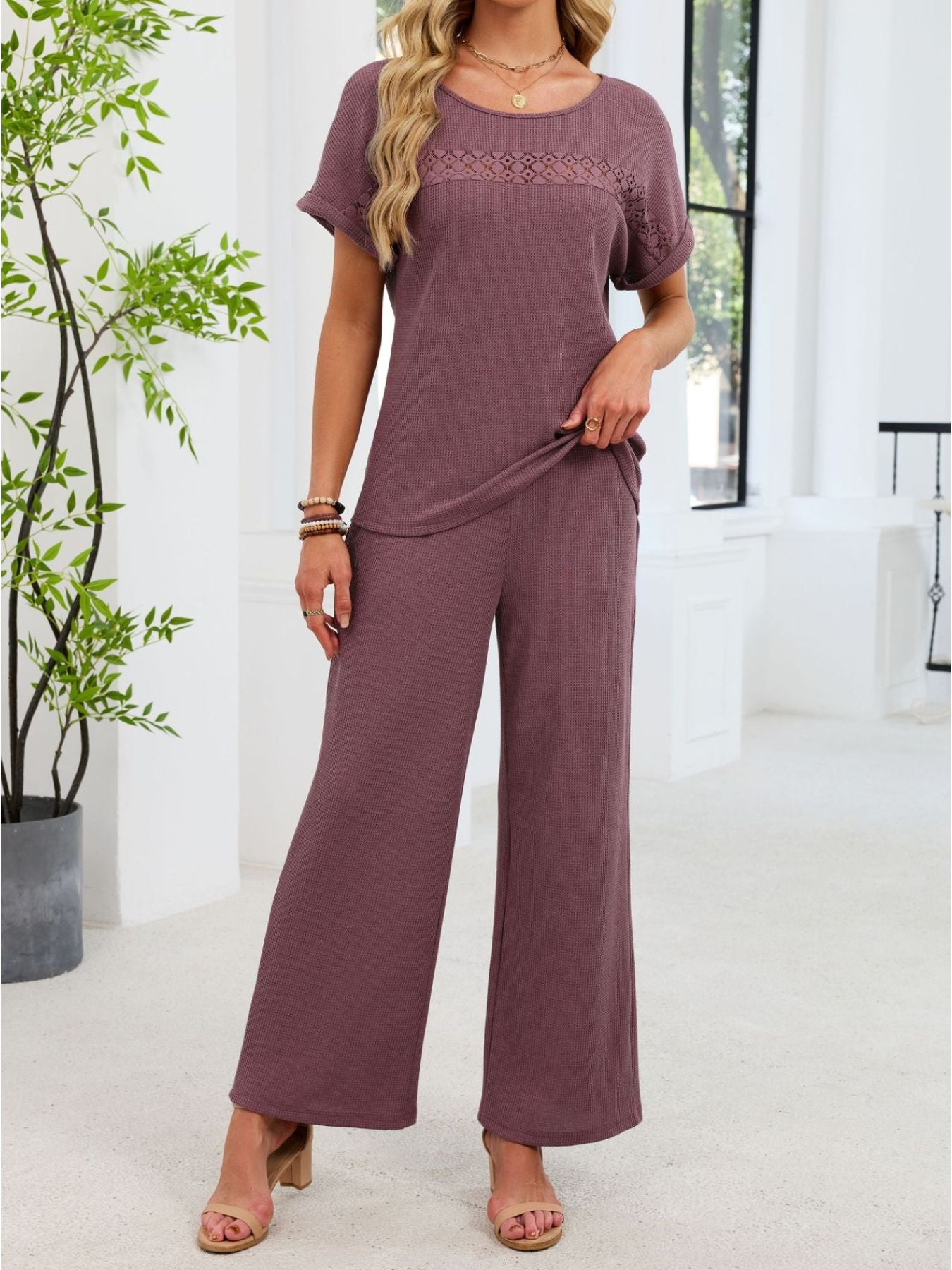 Plum purple lace cutout two-piece set with wide leg pants and short sleeve top.