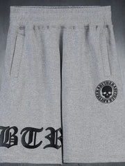 Gray graphic shorts with gothic script and skull logo