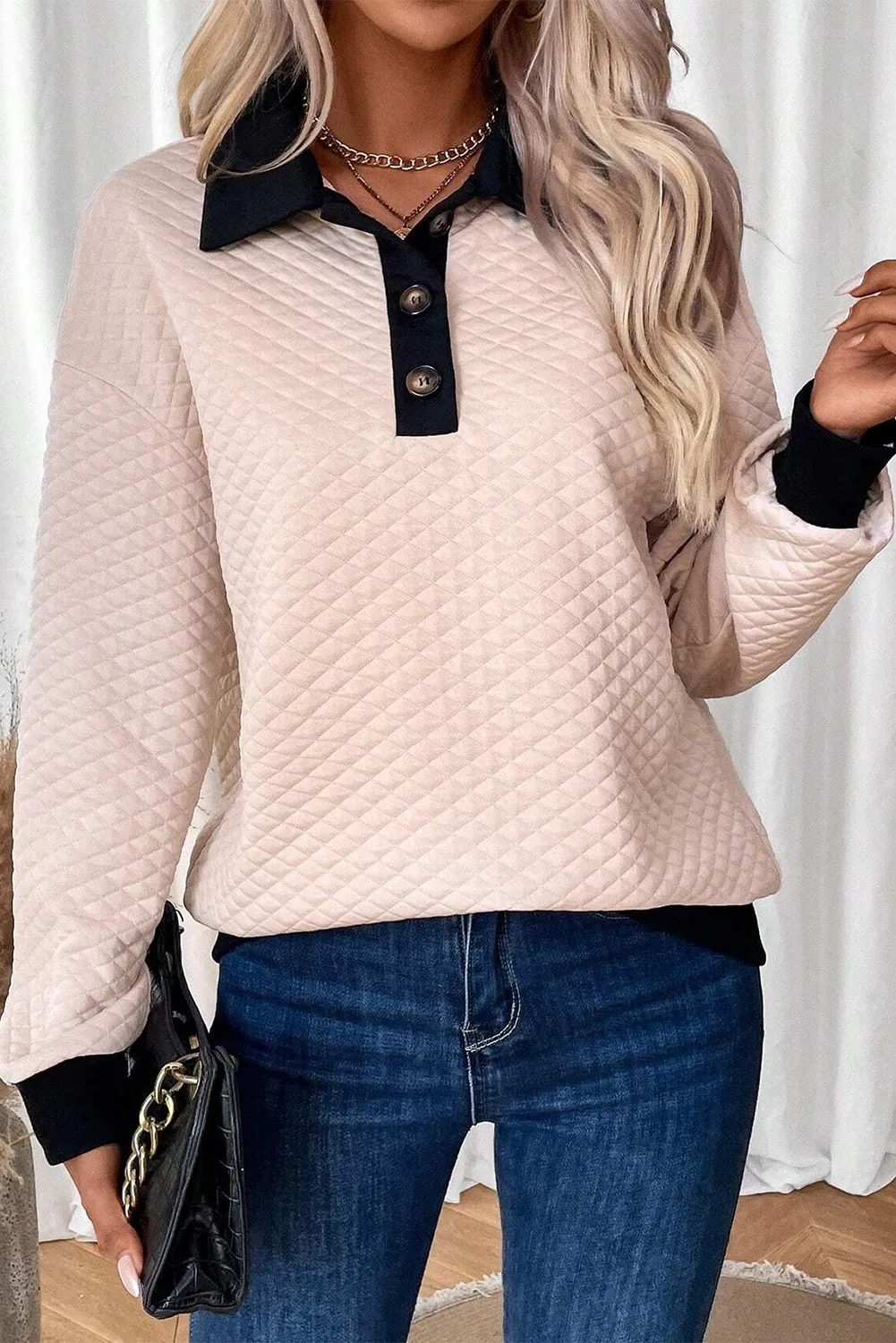 Diamond quilted polo sweatshirt in tan with black collar and buttons, long sleeves.