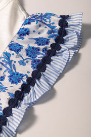 White tee with blue floral embroidered flutter sleeves and striped ruffle trim.