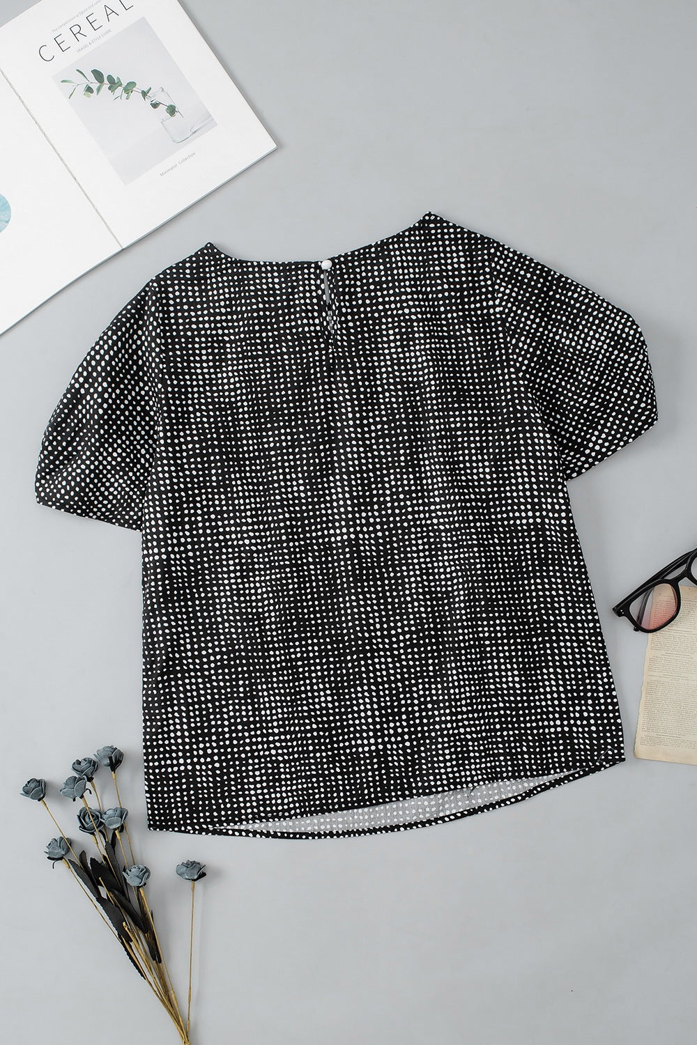Black dotted puff sleeve blouse with crew neck and short sleeves.