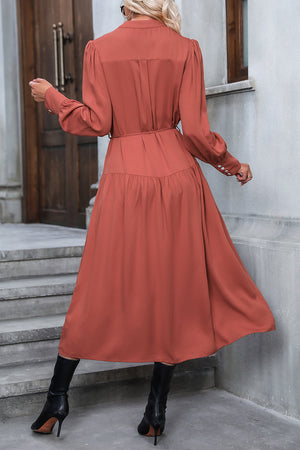 Tiered midi shirt dress in red orange with button cuffs and tie waist.
