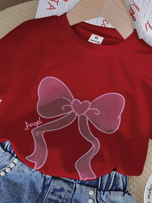 Scarlet tee with pink bowknot graphic and "Angel" text, paired with pearl-button denim shorts.