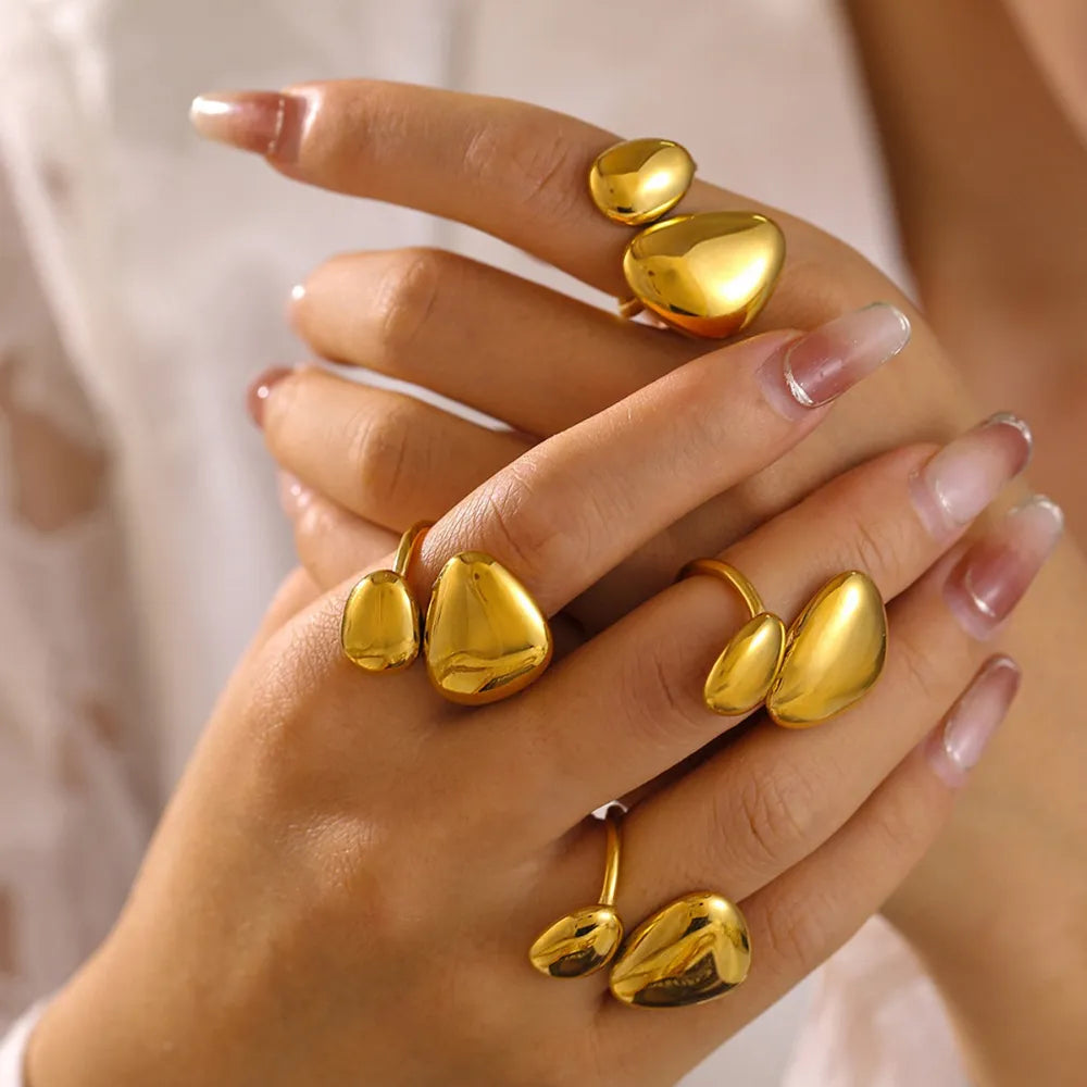 Gold sculptural pebble bypass rings with organic shapes on fingers