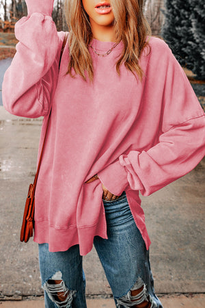 Oversized washed cotton sweatshirt in carnation pink with side slits and ribbed cuffs.