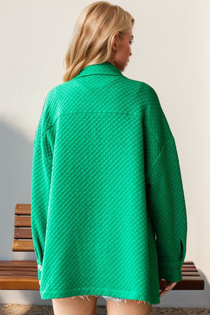 Green diamond quilted oversized shirt jacket with collar and long sleeves.