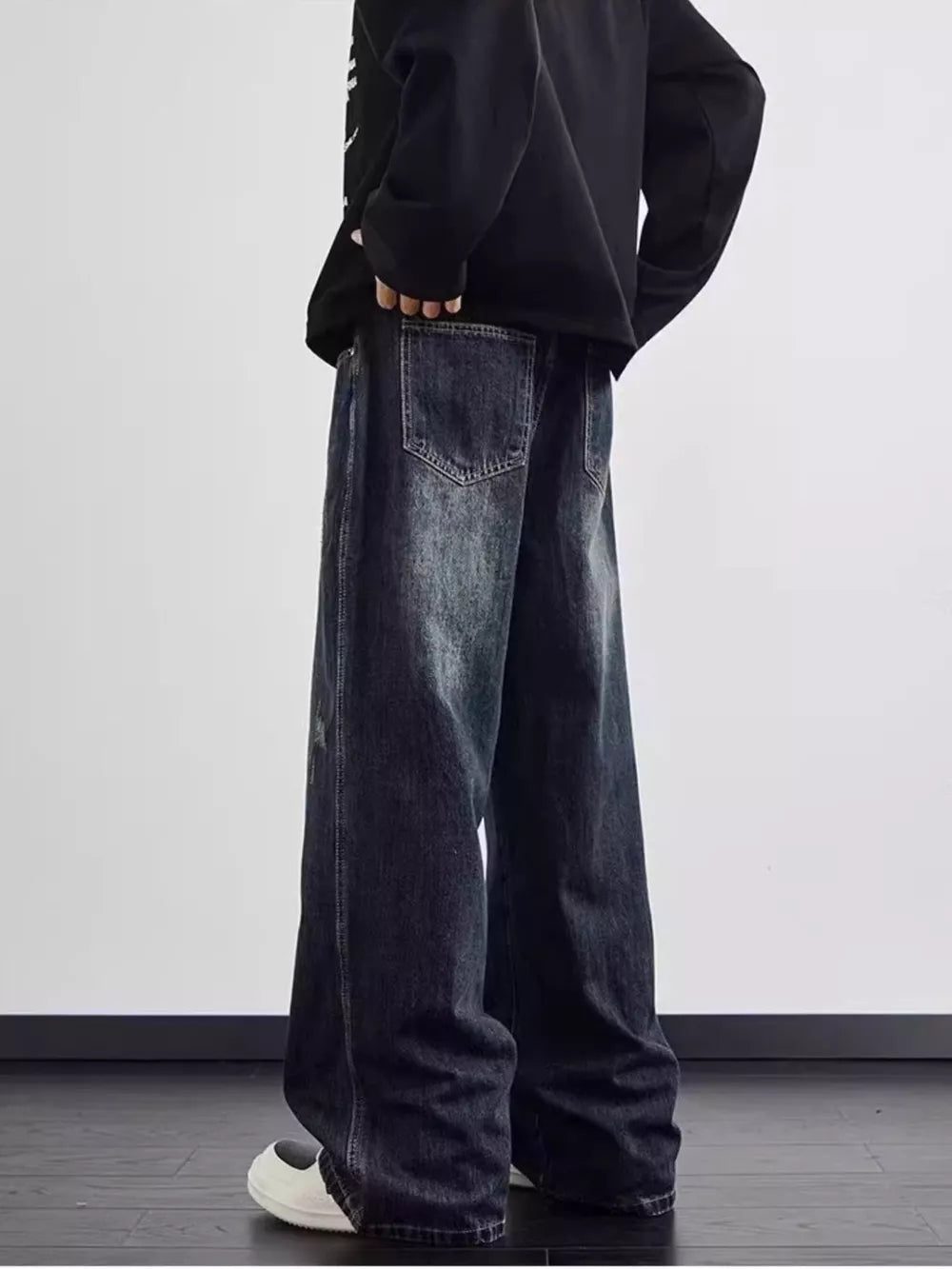 Distressed dark wash wide leg men's jeans with a relaxed fit and visible pocket details.
