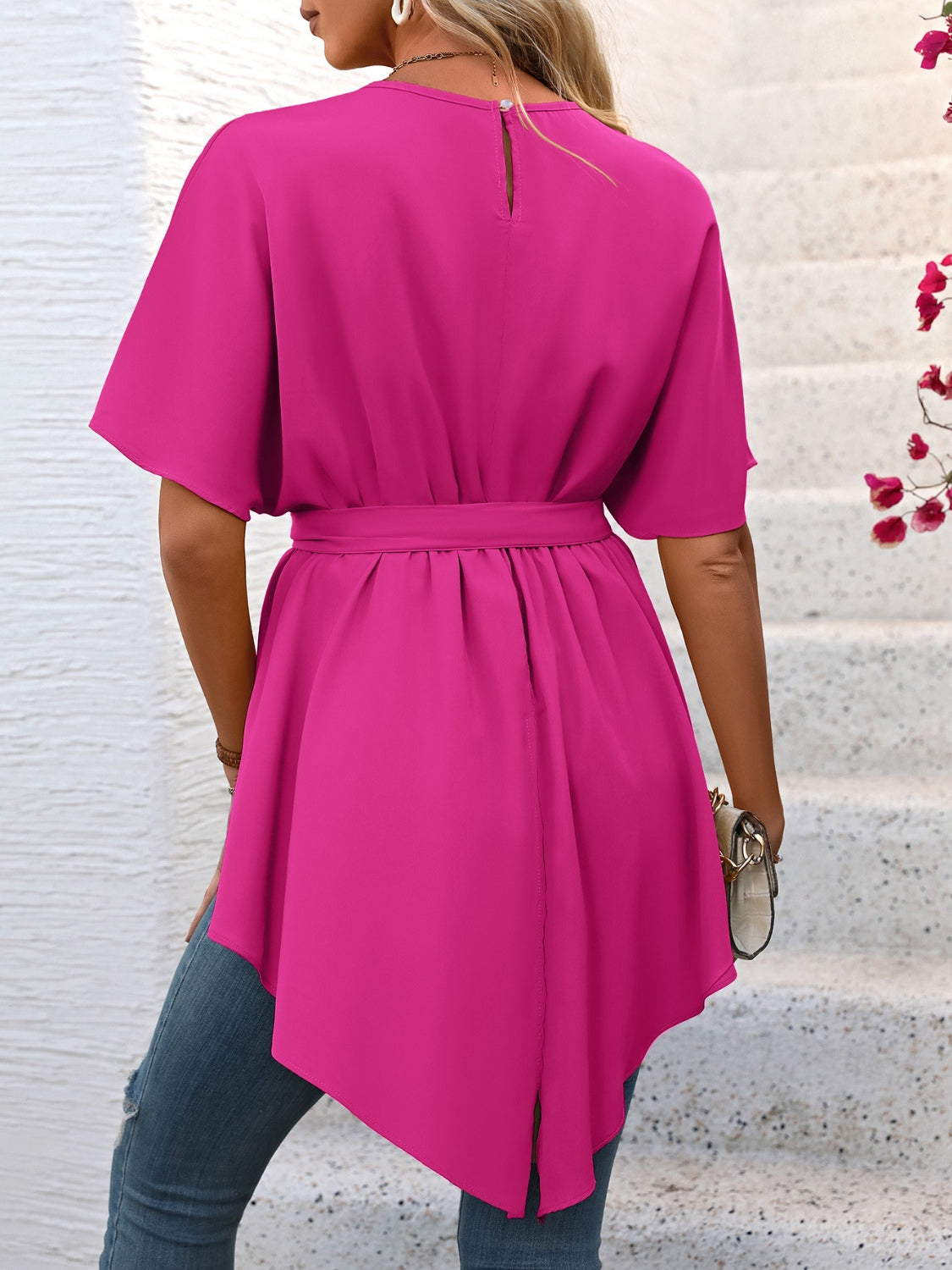 Hot pink blouse with short sleeves, tie waist, and asymmetrical hemline.