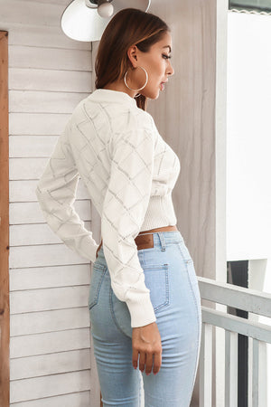 White diamond knit cropped sweater with mock neck and long sleeves.