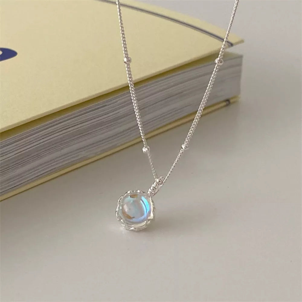 Luminous moonstone pendant necklace in 925 sterling silver with blue hues and delicate charm.
