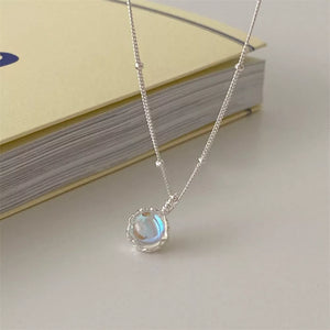 Luminous moonstone pendant necklace in 925 sterling silver with blue hues and delicate charm.