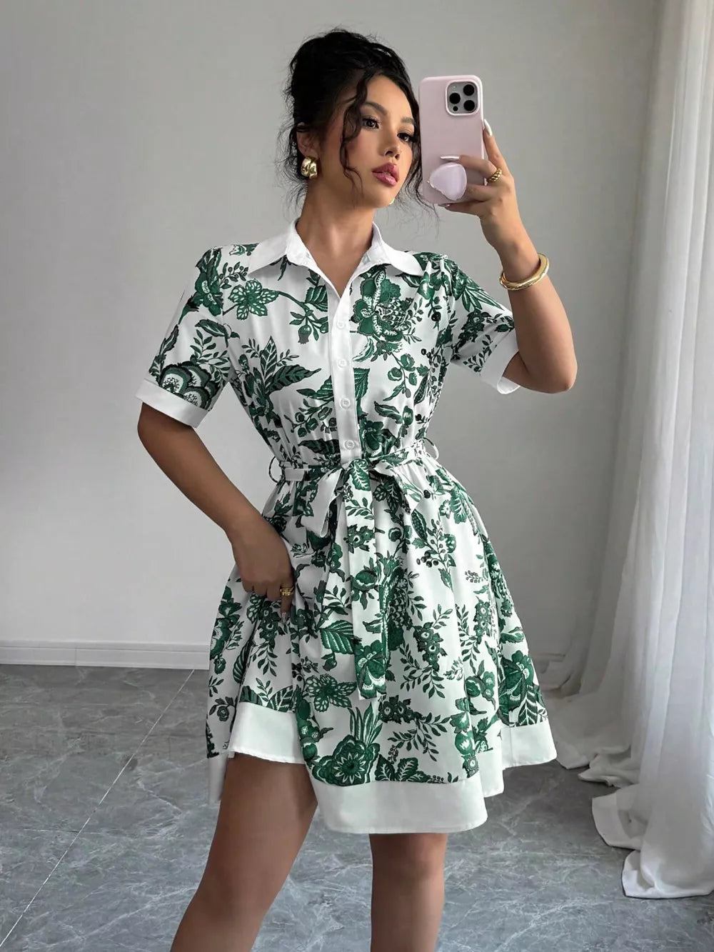 Floral print mini dress in dark green with short sleeves, collar, and tie belt.
