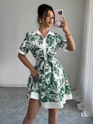 Floral print mini dress in dark green with short sleeves, collar, and tie belt.