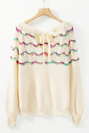 Cream knit sweater with rainbow scallop detail and back tie neckline