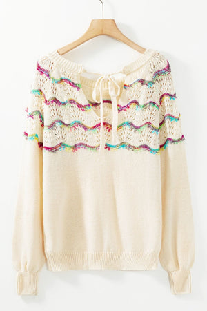 Cream knit sweater with rainbow scallop detail and back tie neckline