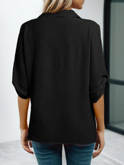Black textured V-neck blouse with roll-up sleeves and a button-down front.