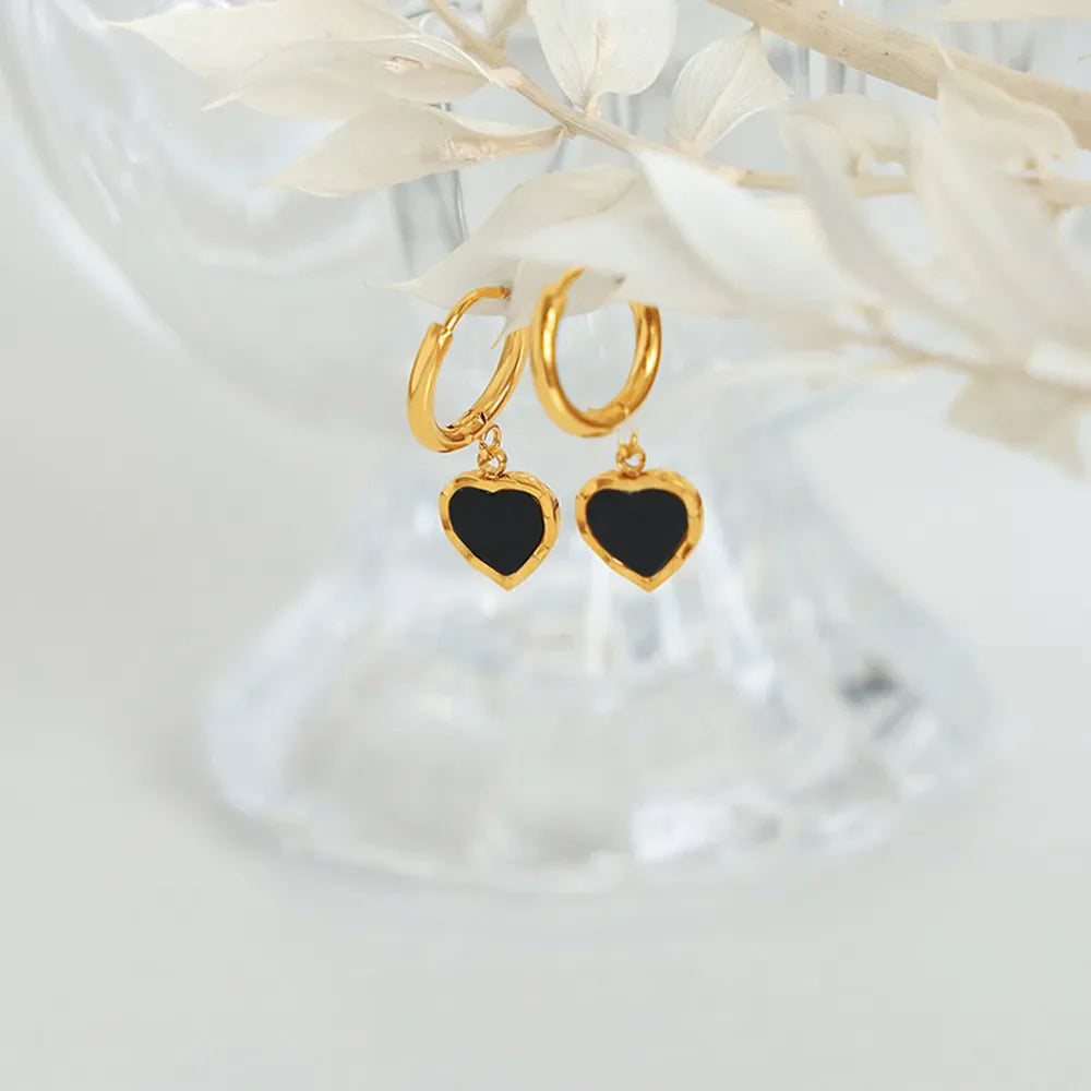 Gold hoop earrings with black enamel heart charms