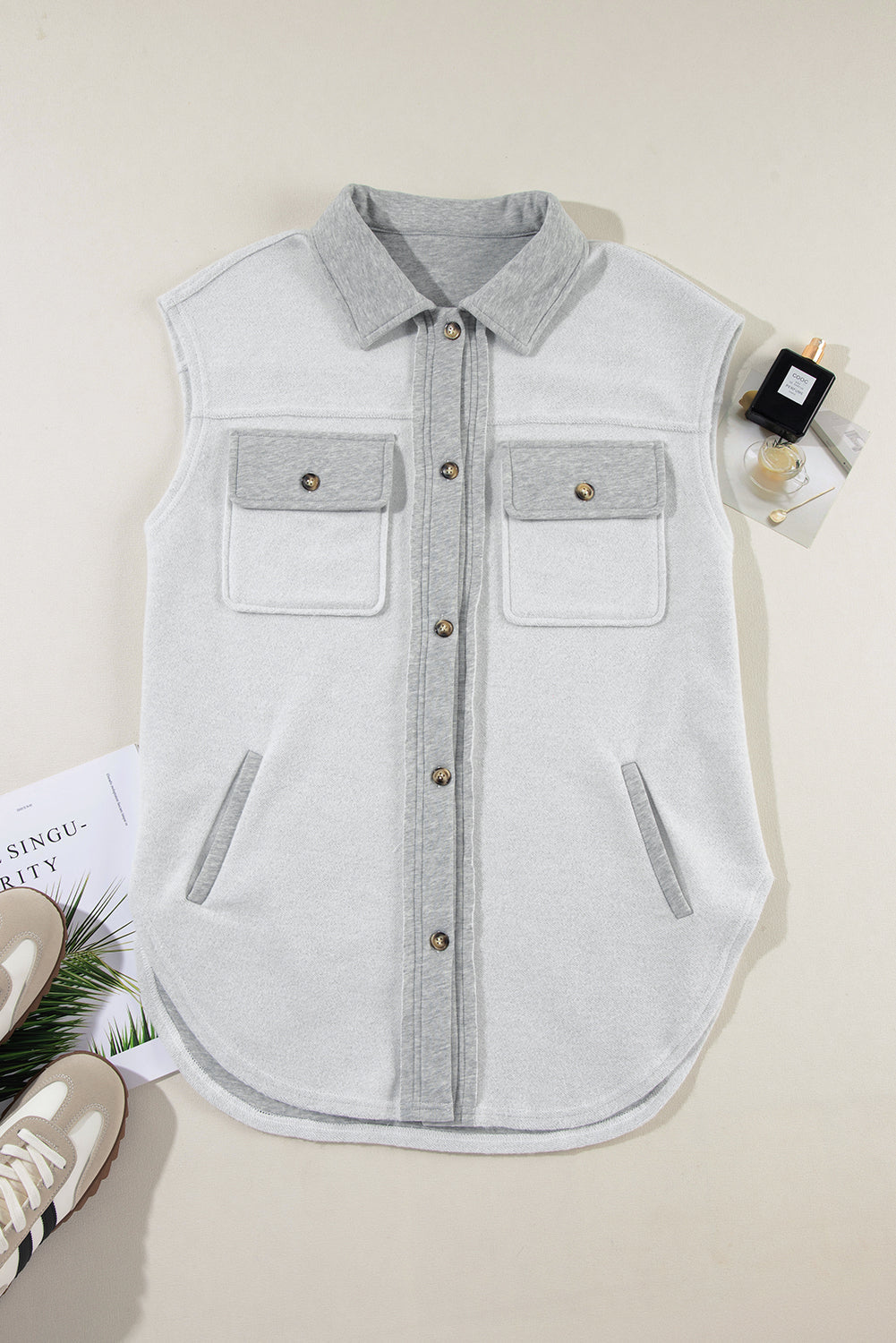 Light gray cotton utility vest with contrast trim, button-down front, and chest pockets.