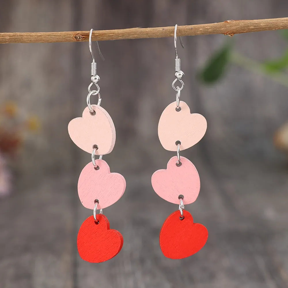 Cascading heartwood dangle earrings in blush pink and red with silver hooks.
