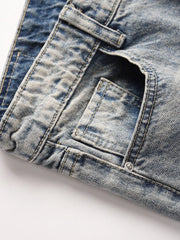 Distressed wash bootcut jeans with raw hem detail in medium blue denim.