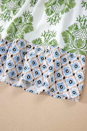 Mini dress with green floral print and blue diamond patchwork ruffle detail.