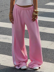 Pink relaxed wide leg sweatpants with white side stripes and elasticated waist.
