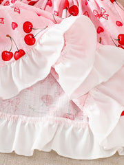 Baby dress with cherry print, ruffle trim, and cotton fabric.