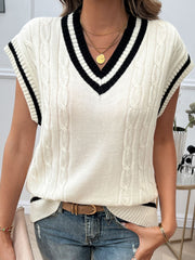 White cable knit vest with black trim and V-neck, acrylic material.