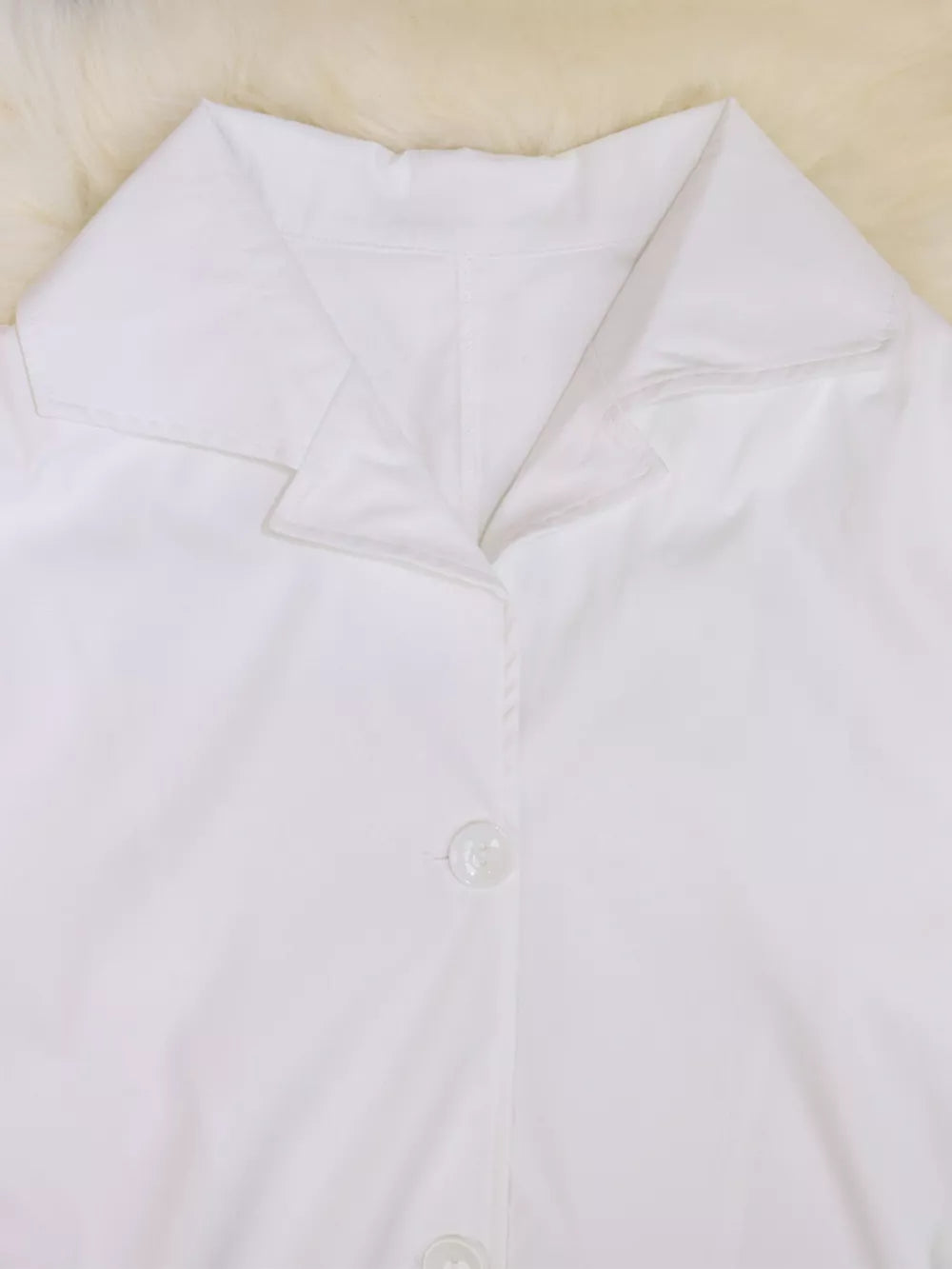 White midi dress with lapel collar and button front detail.