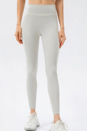Light gray performance leggings with mesh pockets and white sneakers.