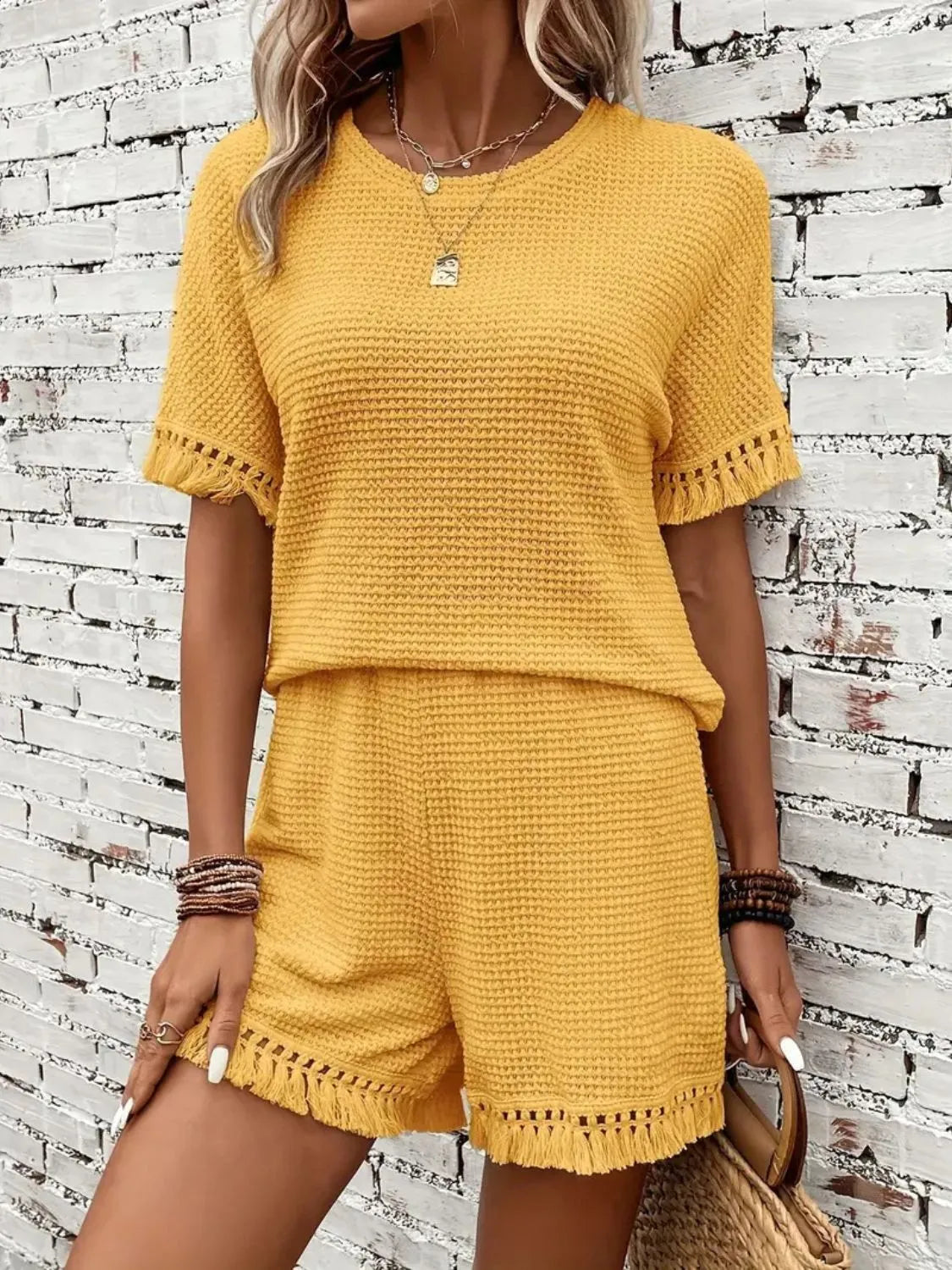 Yellow textured knit set with fringe detail on short sleeves and hem.