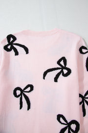 Blush pink knit crewneck sweater with allover black bow motifs.