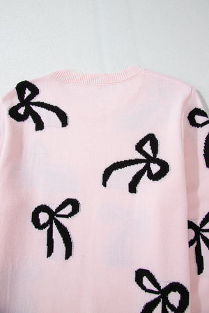 Blush pink knit crewneck sweater with allover black bow motifs.