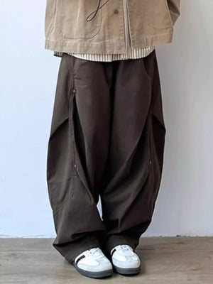 Men's brown loose fit cargo pants with button details and large pockets.