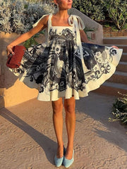 Floral tie-strap mini dress with pockets in black and white pattern.