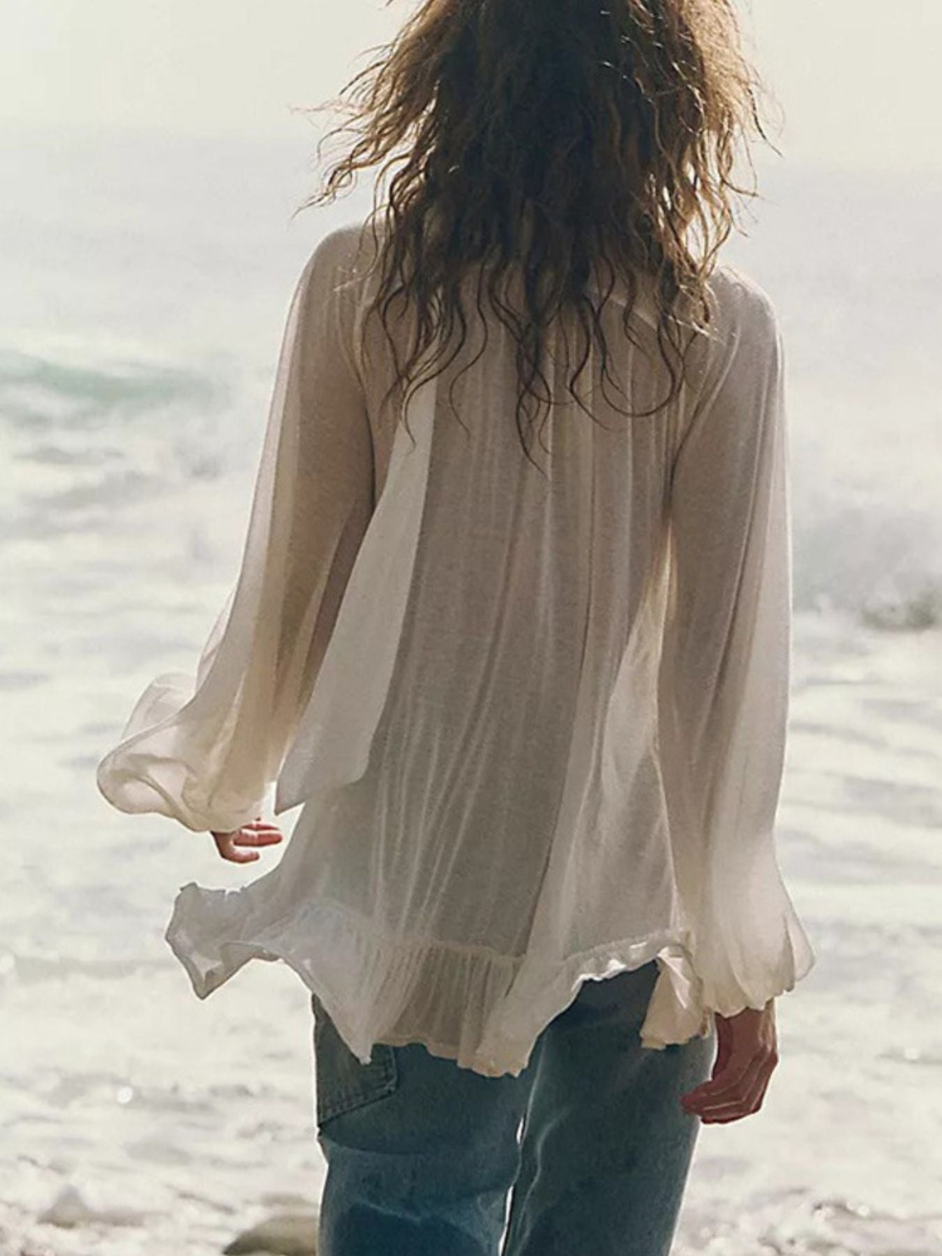 White sheer ruffle trim beach cover-up with long flowy sleeves and a ruffled hem.