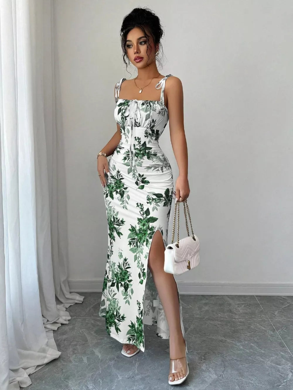 White floral print maxi dress with tie straps, ruched bodice, and thigh-high slit.