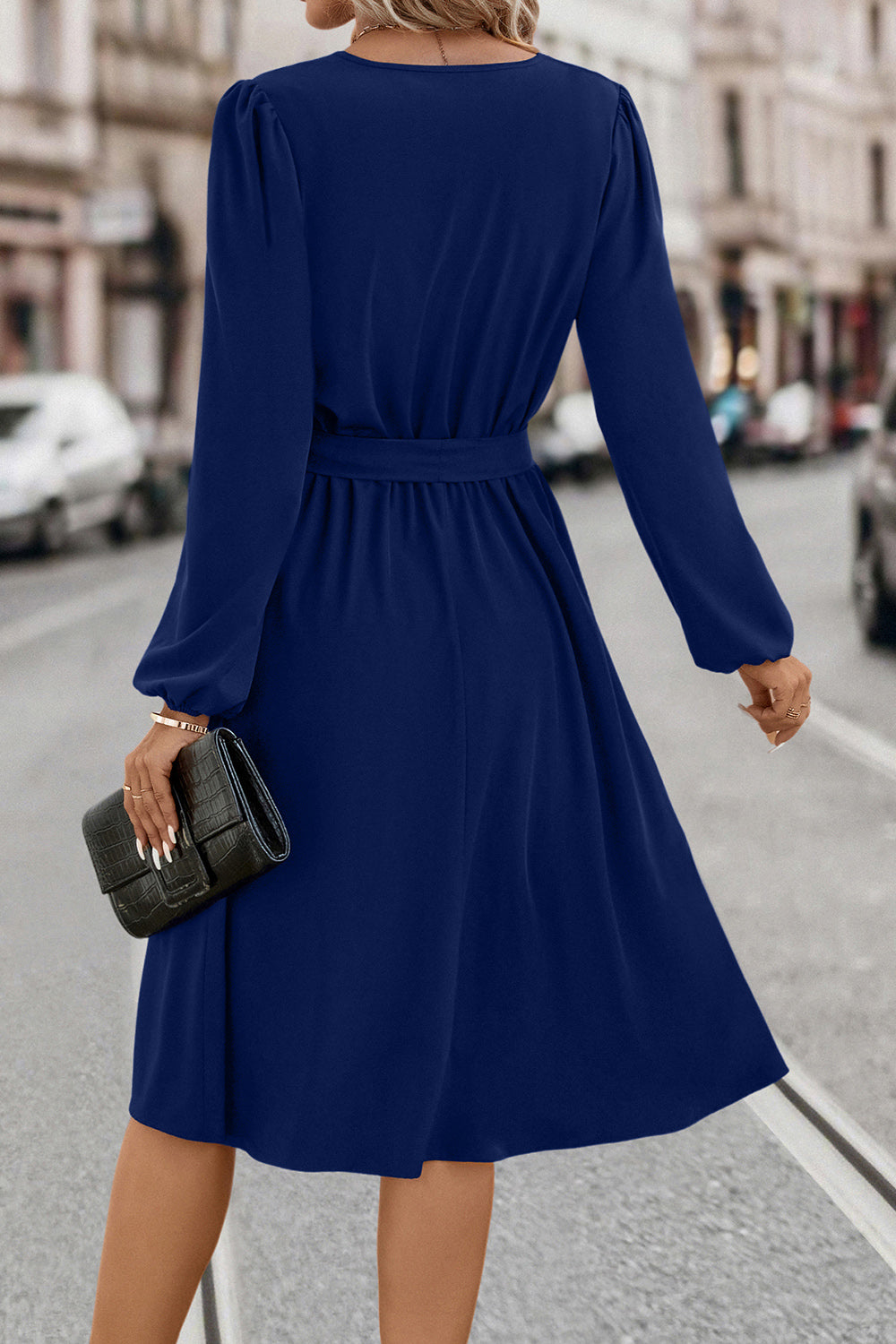 Navy midi dress with poet sleeves, V-neck, and tie waist.