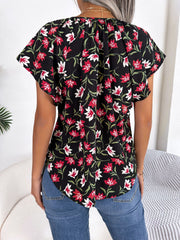 Black floral print blouse with ruffle sleeves and tie-neck detail.