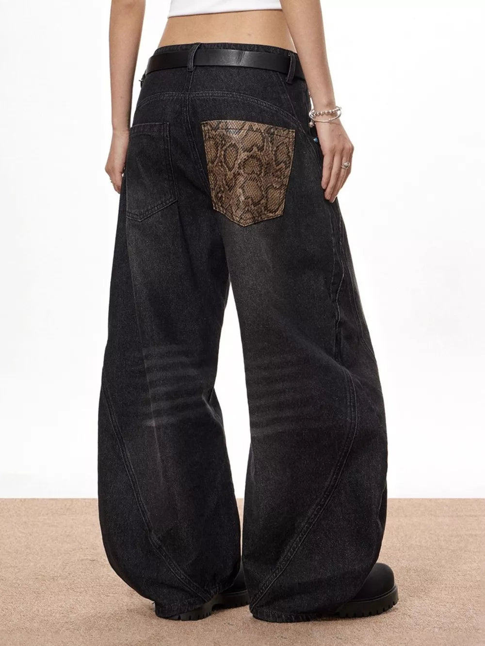 Vintage wide leg jeans in black denim with snake print back pocket accents.