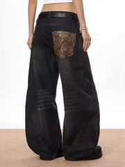 Vintage wide leg jeans in black denim with snake print back pocket accents.
