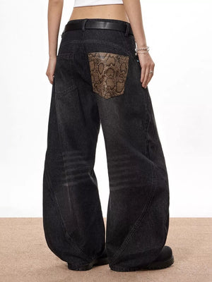 Vintage wide leg jeans in black denim with snake print back pocket accents.