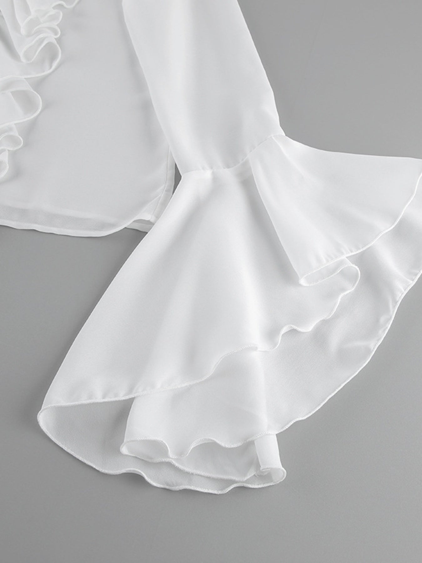 White ruffled flounce sleeve blouse with layered flounce detail.
