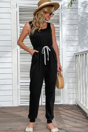 Black sleeveless jogger jumpsuit with contrast drawstring tie and cuffed ankles.