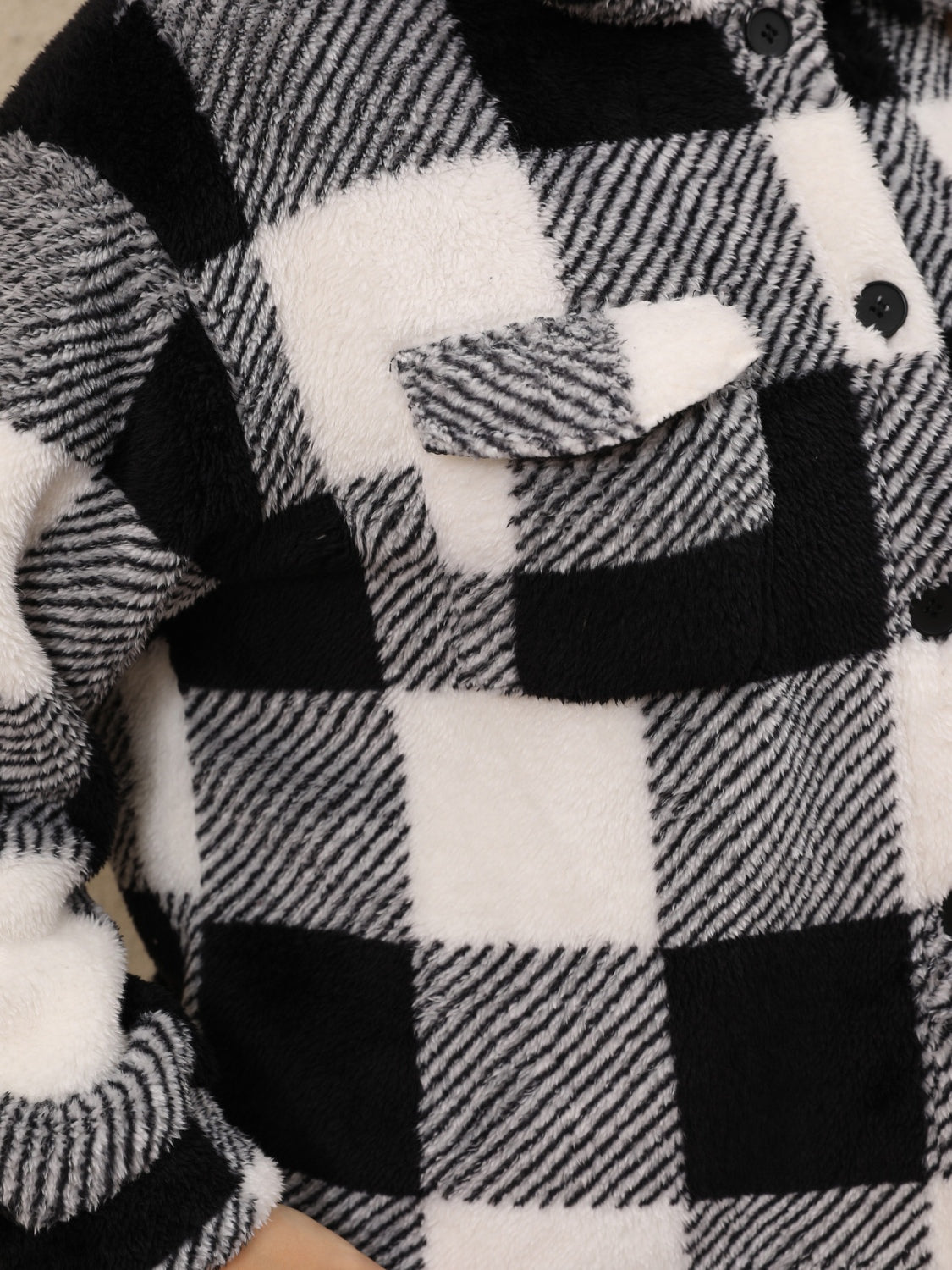 Black and white plaid shacket with fluffy texture and chest pocket.